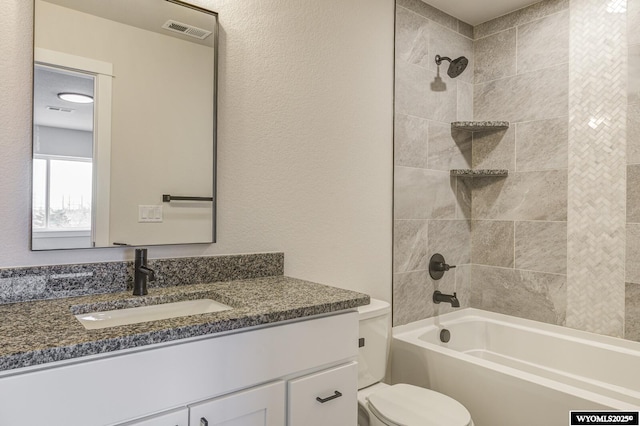 full bathroom with tiled shower / bath combo, vanity, and toilet