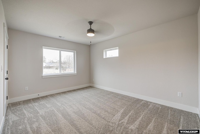 unfurnished room with ceiling fan and carpet