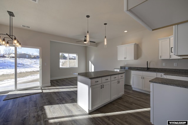 kitchen featuring sink, white cabinetry, dark hardwood / wood-style floors, a kitchen island, and ceiling fan