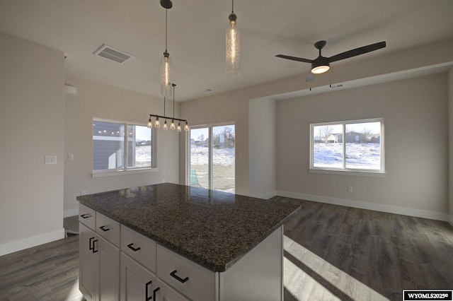 kitchen featuring a center island, dark stone countertops, white cabinets, and dark hardwood / wood-style floors