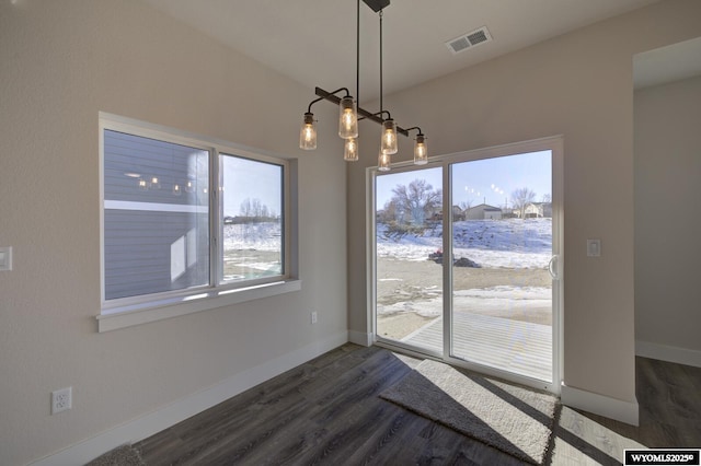 unfurnished dining area with dark hardwood / wood-style flooring and a chandelier