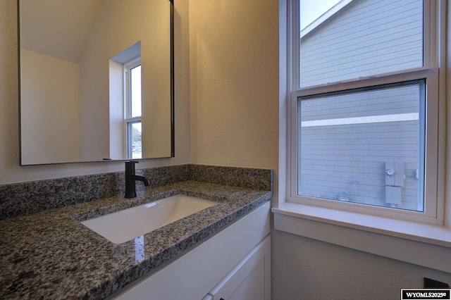 bathroom with lofted ceiling and vanity