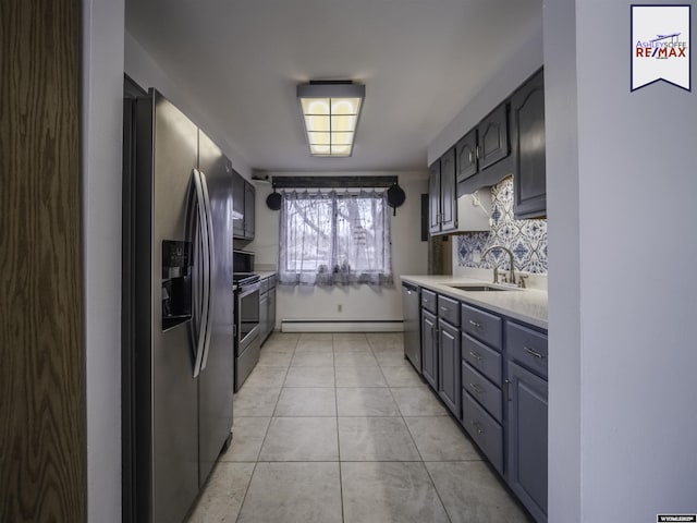 kitchen with sink, light tile patterned floors, backsplash, stainless steel appliances, and a baseboard radiator