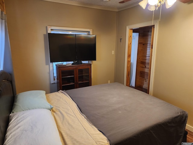 bedroom featuring hardwood / wood-style flooring, ornamental molding, a textured ceiling, and ceiling fan