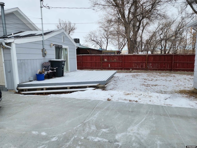 snow covered patio featuring a deck