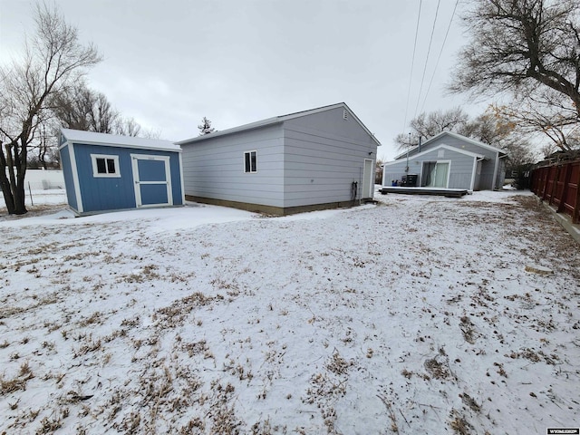 snow covered property with a storage unit