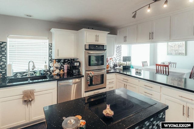 kitchen with white cabinetry, a healthy amount of sunlight, stainless steel appliances, and sink