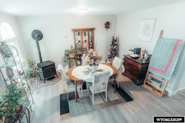 dining room featuring a wood stove and light wood-type flooring