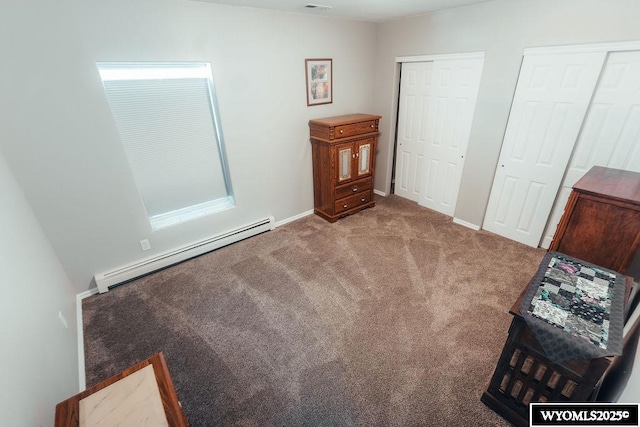 unfurnished bedroom with light carpet, a baseboard heating unit, and two closets