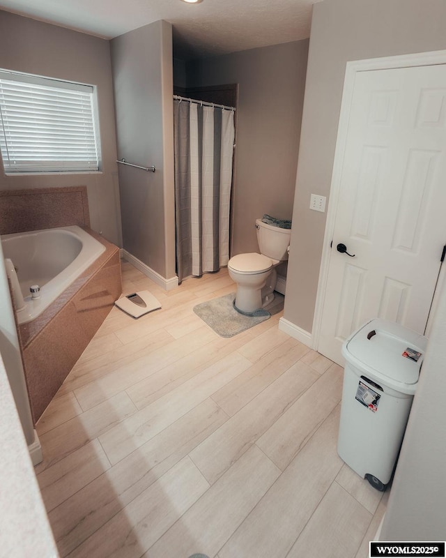 bathroom featuring hardwood / wood-style flooring, a bath, and toilet