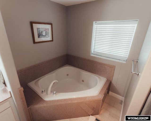 bathroom featuring a relaxing tiled tub, vanity, and tile patterned flooring