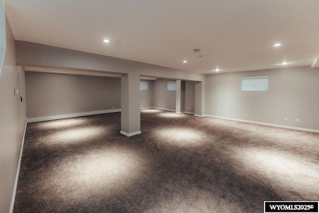 basement featuring baseboard heating and dark colored carpet