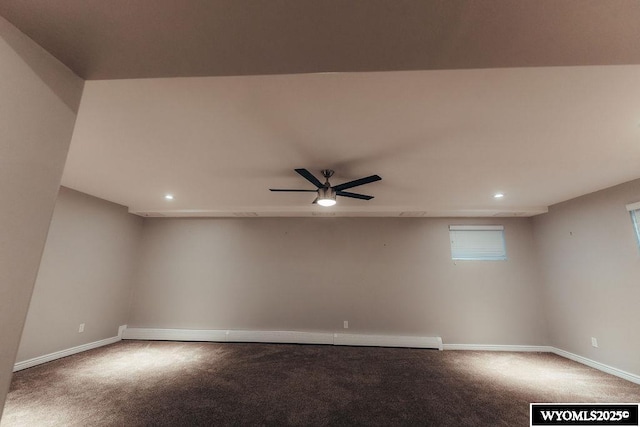 carpeted empty room featuring a baseboard heating unit and ceiling fan