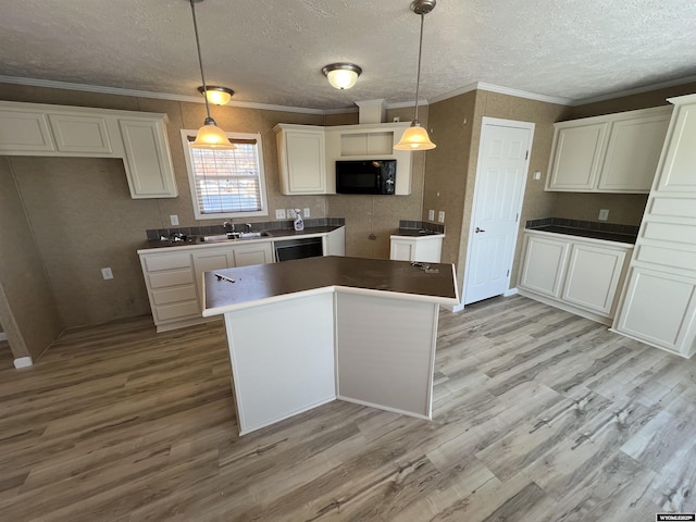 kitchen with hanging light fixtures, white cabinetry, ornamental molding, and black appliances