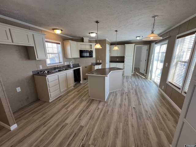 kitchen featuring sink, white cabinetry, hanging light fixtures, ornamental molding, and a kitchen island