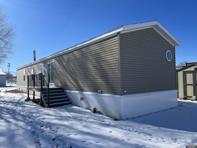 snow covered property featuring a storage unit