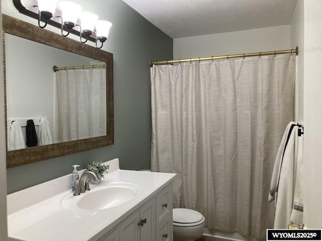 bathroom featuring vanity, a textured ceiling, and toilet