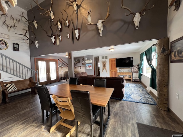 dining room featuring dark hardwood / wood-style flooring, plenty of natural light, french doors, and a high ceiling