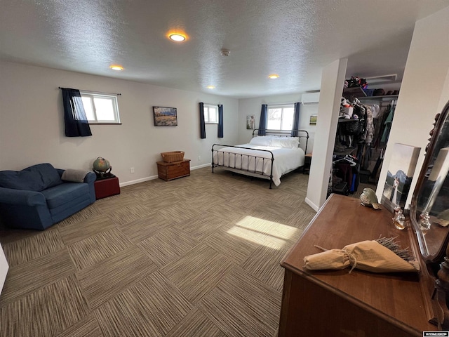 bedroom with multiple windows, a closet, and a textured ceiling