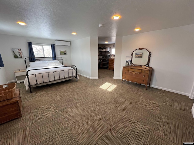 bedroom featuring a textured ceiling and an AC wall unit