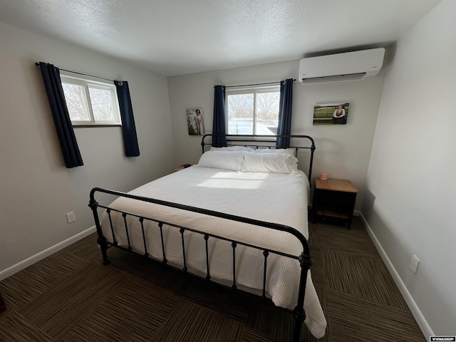 bedroom with a textured ceiling and an AC wall unit