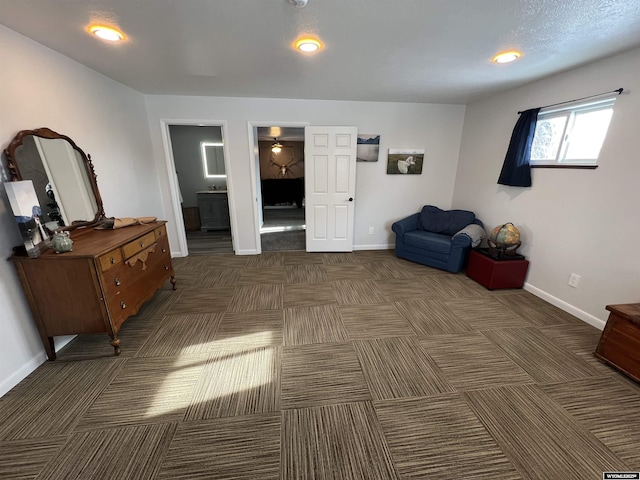 bedroom featuring connected bathroom and dark carpet