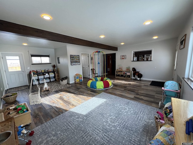 recreation room featuring dark hardwood / wood-style flooring and beam ceiling