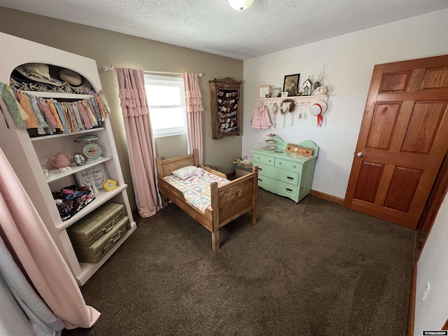 bedroom with dark carpet and a textured ceiling