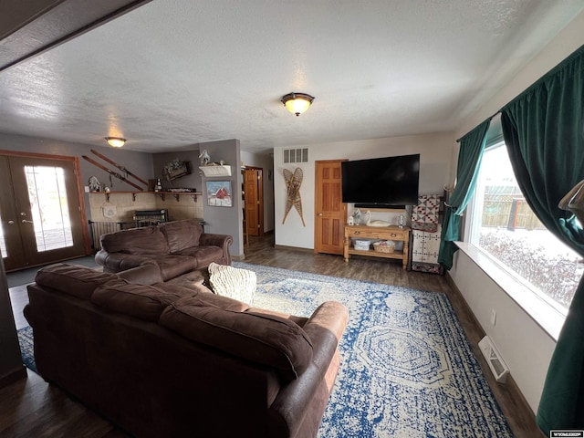 living room with dark hardwood / wood-style flooring and a textured ceiling