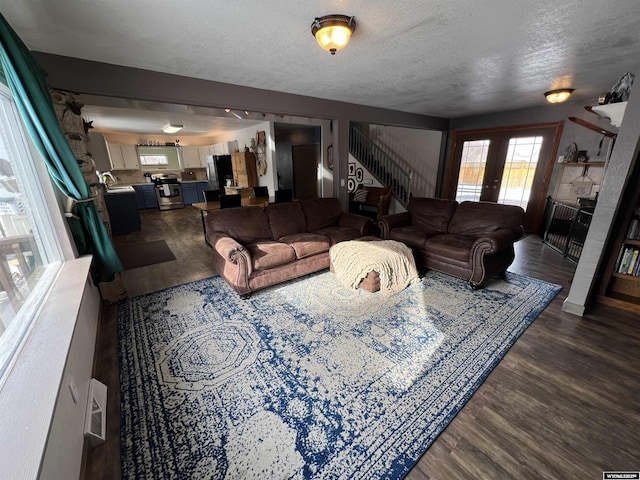 living room with dark hardwood / wood-style floors, sink, a textured ceiling, and french doors