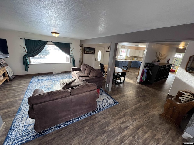 living room with dark wood-type flooring and a textured ceiling