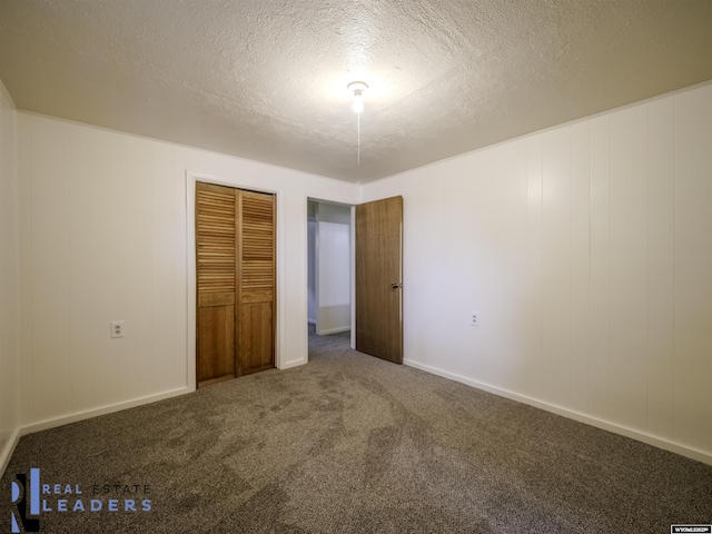 unfurnished bedroom with carpet, a textured ceiling, and a closet