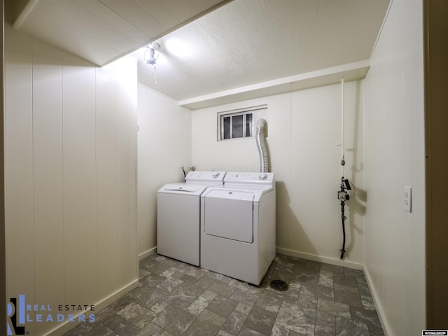 laundry room featuring wooden walls and washing machine and dryer