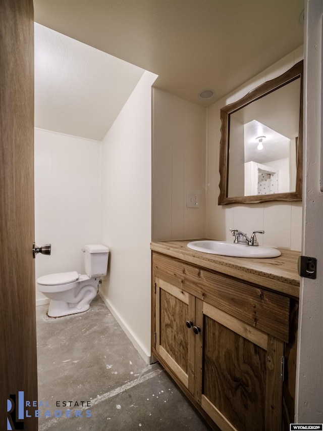 bathroom featuring vanity, concrete floors, and toilet