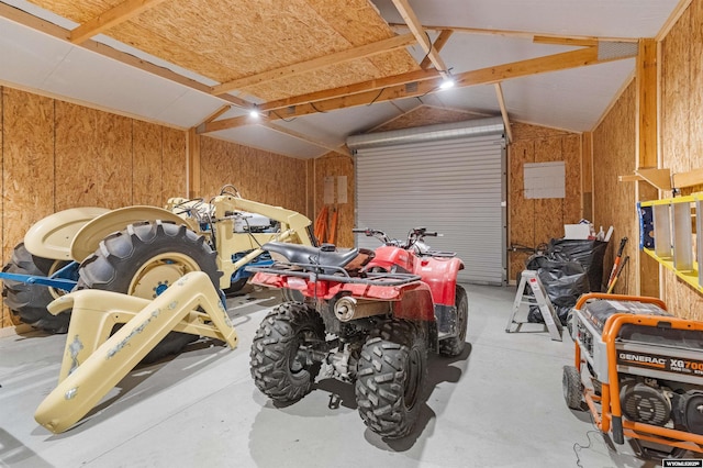 garage with a carport and wooden walls