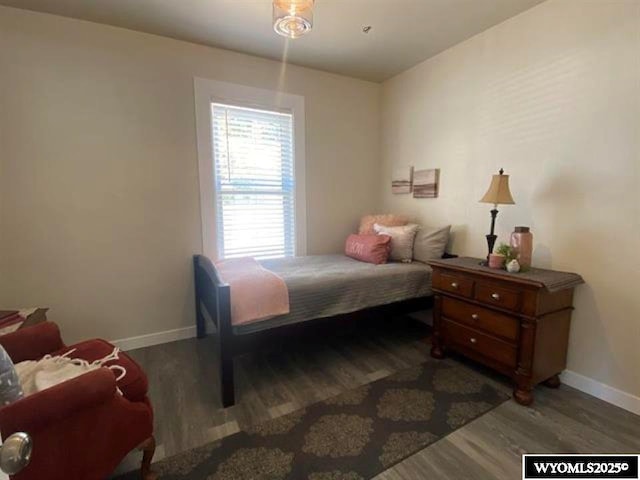 bedroom featuring baseboards and wood finished floors