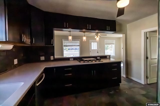 kitchen featuring baseboards, a peninsula, stainless steel gas stovetop, and ceiling fan