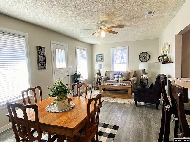 dining room featuring dark wood-type flooring, a textured ceiling, and ceiling fan