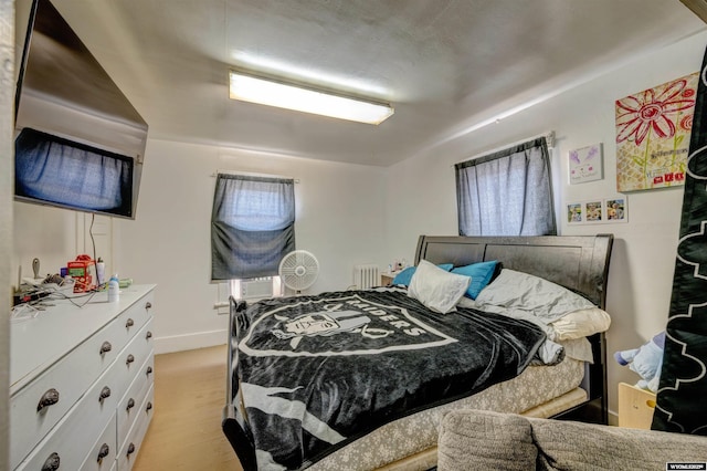 bedroom featuring radiator and light wood-type flooring