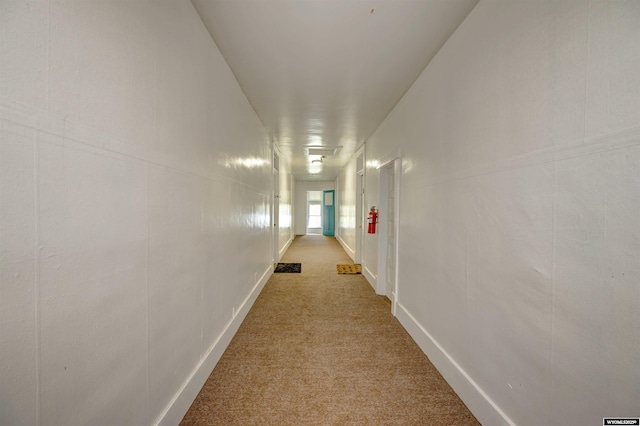 hallway featuring light colored carpet