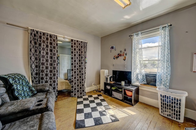 interior space featuring radiator heating unit, light hardwood / wood-style floors, and cooling unit