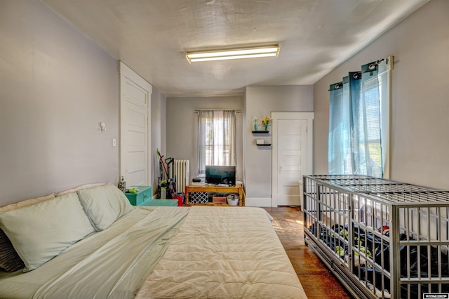 bedroom with hardwood / wood-style flooring and radiator heating unit