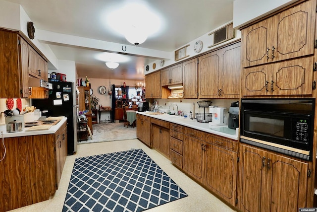 kitchen with stainless steel refrigerator, light colored carpet, and black microwave