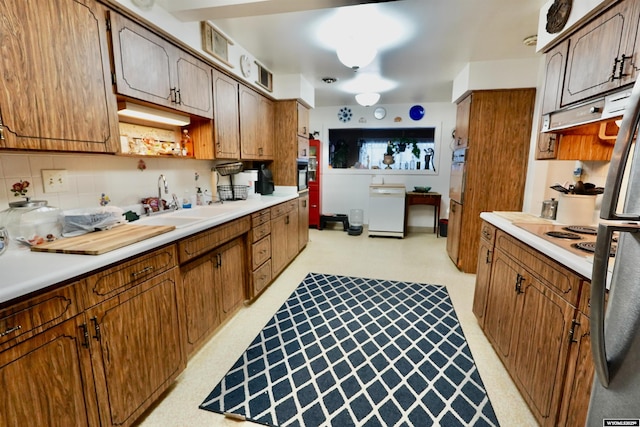 kitchen featuring tasteful backsplash, sink, and stovetop