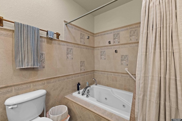 full bath with toilet and tile walls