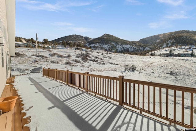 snow covered deck featuring a mountain view