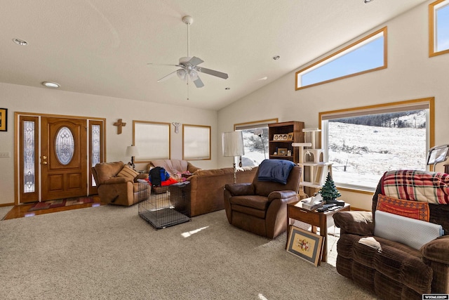 carpeted living area with high vaulted ceiling and a ceiling fan