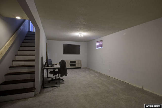 carpeted office featuring a textured ceiling