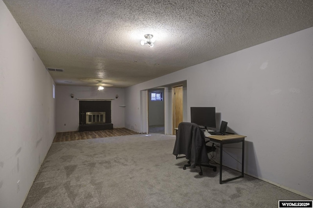 carpeted office featuring a textured ceiling