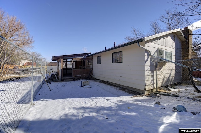 view of snow covered rear of property